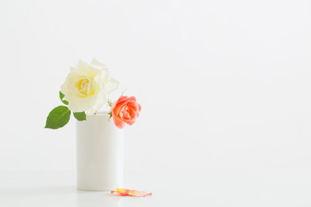 roses in white cup on white wooden table