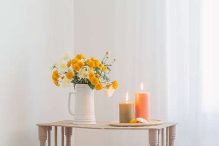 autumn flowers with burning candles on vintage wooden shelfの写真素材