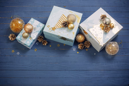 Christmas gifts with golden decorations on blue wooden background