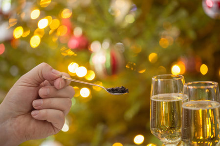 black caviar in spoon and glass of champagne