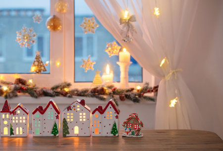 Christmas toy houses on background of decorated windowの写真素材