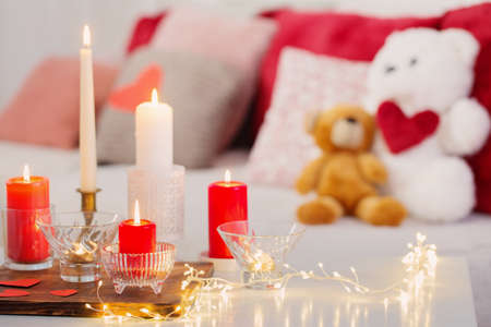 Burning candles on white table in interior. Valentines day conceptの写真素材