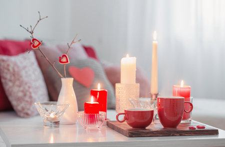 Burning candles on white table in interior. Valentines day conceptの写真素材