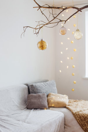 Christmas balls on golden branch in white interiorの写真素材