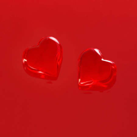red glass hearts on red background
