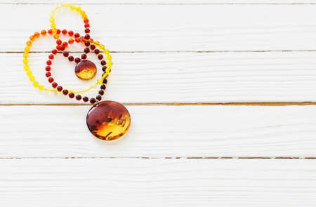 amber necklace on white wooden backgroundの写真素材