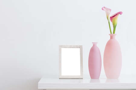 beautiful pink flowers in vases and wooden frame on white backgroundの写真素材