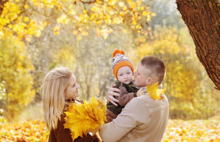 happy family with little baby in autumn parkの写真素材