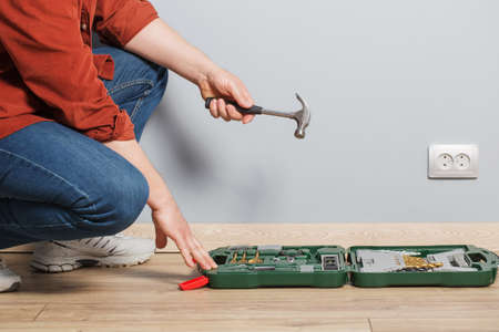 middle-aged man with set of repair tools on wooden floorの写真素材