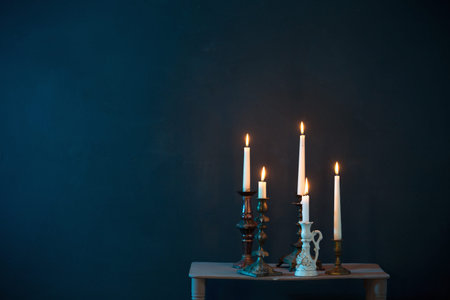 candlesticks with burning candles on dark blue background