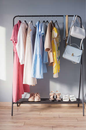 light colored womens summer clothes and shoes on hangerの写真素材