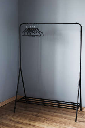 empty black clothes hanger on gray wall backgroundの写真素材