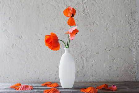 red poppies in white vase on white backgroundの写真素材