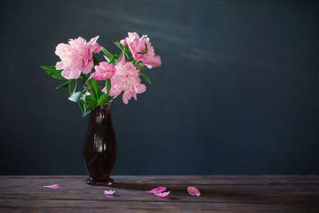 pink peony in vase on background dark wallの写真素材