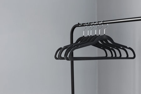 empty black clothes hanger on gray wall background
