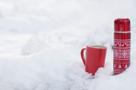 tea in red flask in winter forestの写真素材