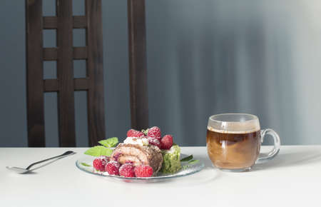 cup of coffee and dessert with raspberries on white table on background blue wallの写真素材