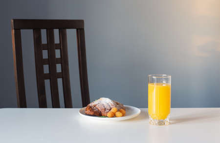 croissant with orange juice on white tableの写真素材