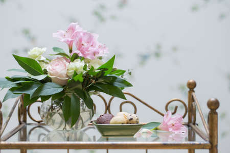 cookies and bouquet in glass vase in vintage interiorの写真素材