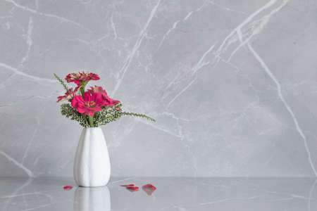 pink zinnia flowers on vase on marble backgroundの写真素材