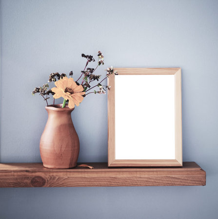 autumn flowers in rustic ceramic vase and isolated frame on background gray wall