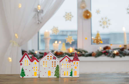 Christmas toy houses on background of decorated windowの写真素材