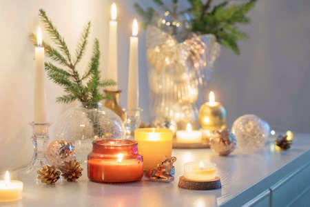 christmas decorations with burning candles in white roomの写真素材