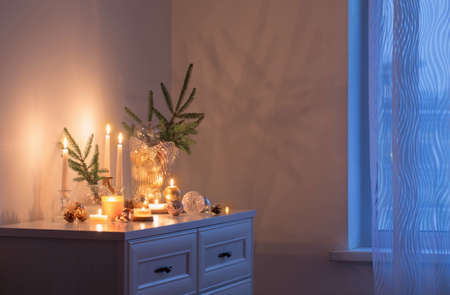 christmas decorations with burning candles in white roomの写真素材