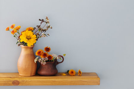 autumn flowers in rustic ceramic vase on background gray wallの写真素材