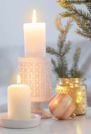 Christmas decorations with burning candles in white interiorの写真素材