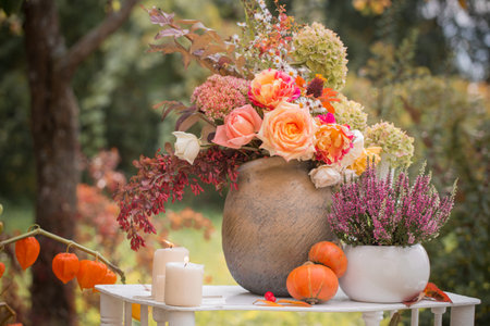 beautiful autumn decor with flowers, berries, pumpkins in gardenの写真素材