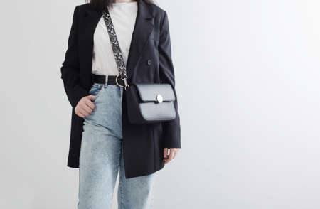 modern young woman in black blazer and blue jeans on white backgroundの写真素材
