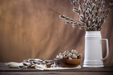 Easter eggs and willow branches on brown background