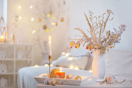christmas home decorations with candles in white interiorの写真素材