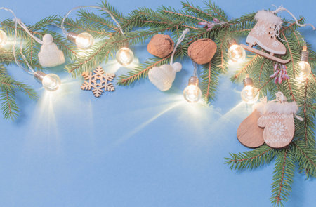 christmas wooden decorations with lights on blue paper background