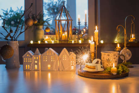 hot drink with cake and christmas decorations on white table in kitchenの写真素材
