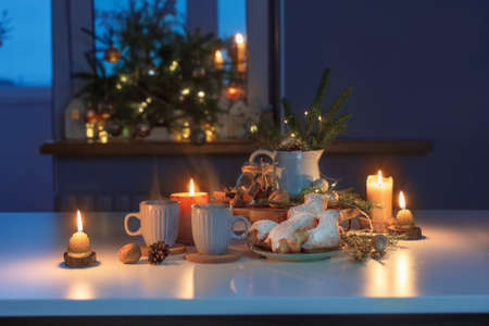 two cups of tea with homemade christmas baked goods on kitchen with christmas decorationの写真素材