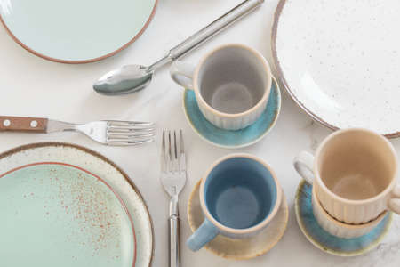 ceramic cups and plates on white marble tableの写真素材