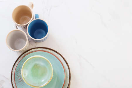 ceramic cups and plates on white marble tableの写真素材