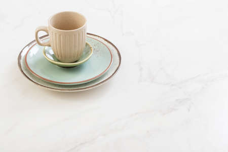 ceramic cup and plate on white marble tableの写真素材