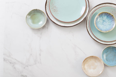 assorted ceramic plates on white marble table
