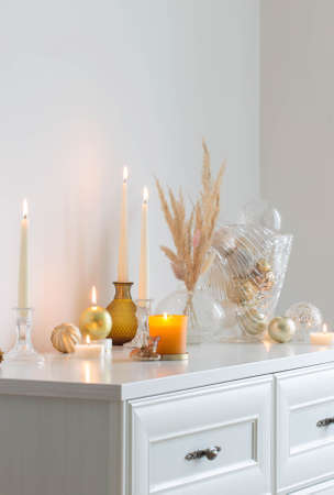 christmas decorations with burning candles in white roomの写真素材
