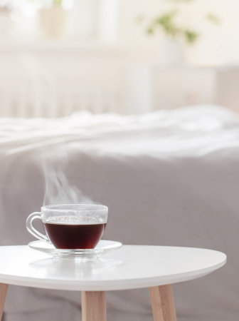 glass cup of coffee on white table in bedroomの写真素材