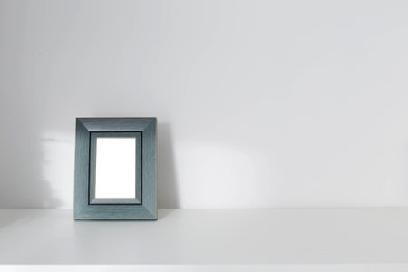 vintage green wooden frame on wooden shelf on background white wall