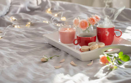 two red cups of coffee and flowers on bedの写真素材