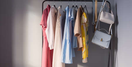 light colored womens summer clothes and shoes on hangerの写真素材