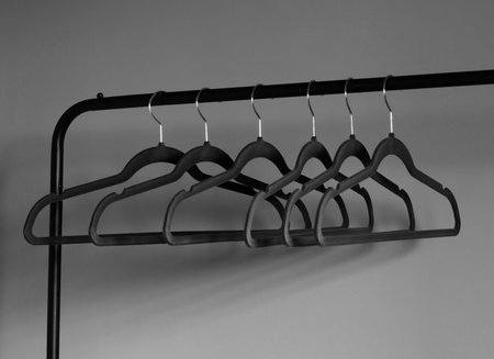 empty black clothes hanger on gray wall background