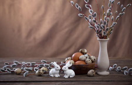 Easter eggs and willow branches on brown backgroundの写真素材