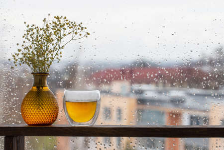hot tea in thermo glass on background window with raindropsの写真素材