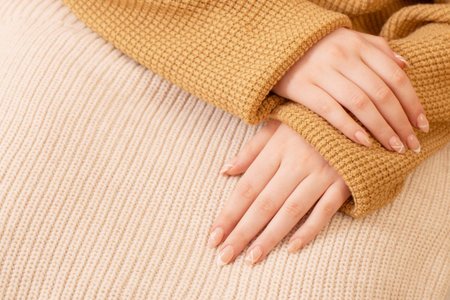 woman's hands with manicure with knitted blanketの写真素材